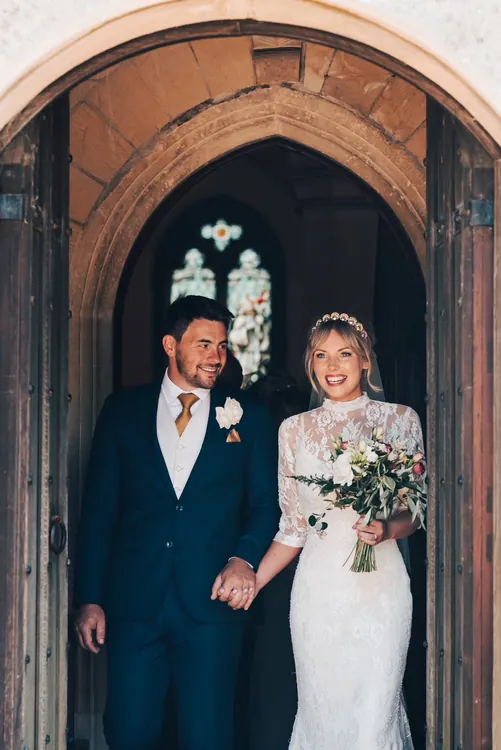 Bride and groom standing in a rustic stone doorway
