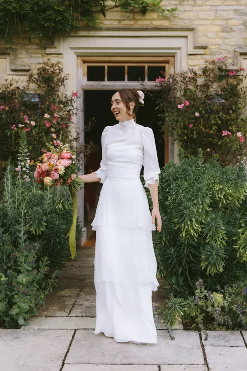Bride outside a stone country house in an elegant gown
